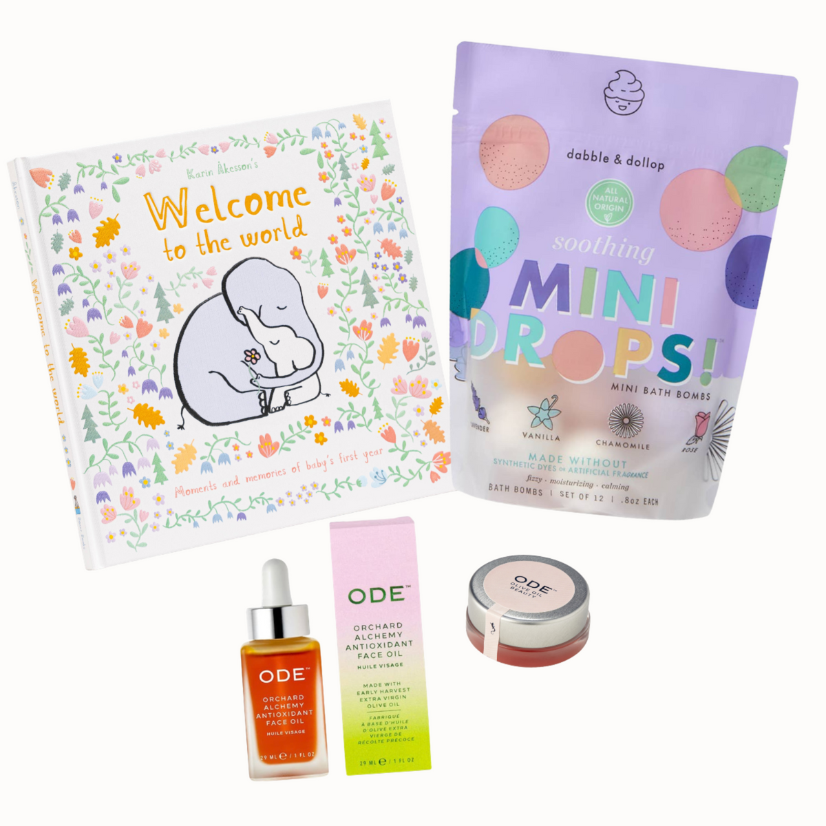 A curated gift set featuring a 'Welcome to the world' baby book by Love Languages, a purple stand-up pouch of ODE 'Soothing Mini Drops' bath bombs, an ODE facial serum bottle, a pink ODE box, and an ODE jar, all arranged on a clean white background. Little Birdies Hello Mama Gift Set to pamper a new mom